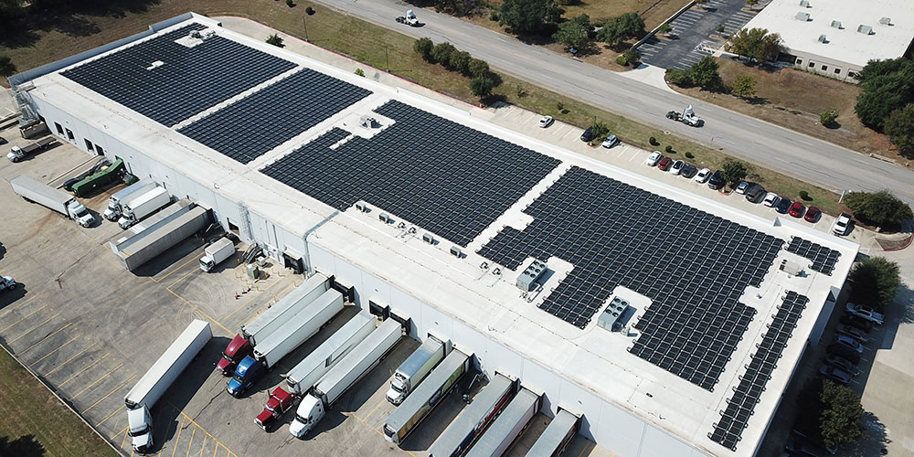 Solar panels atop an industrial building. Solar panels atop an industrial building.